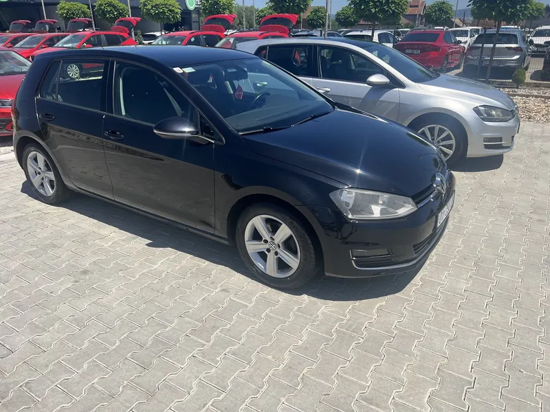 Black Volkswagen Golf parked next to a silver Golf