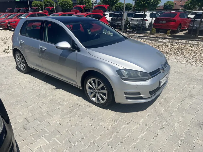 Silver Volkswagen Golf from the side, parked on a paved lot