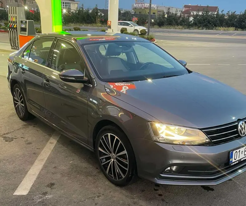 Grey Volkswagen sedan with its headlights on